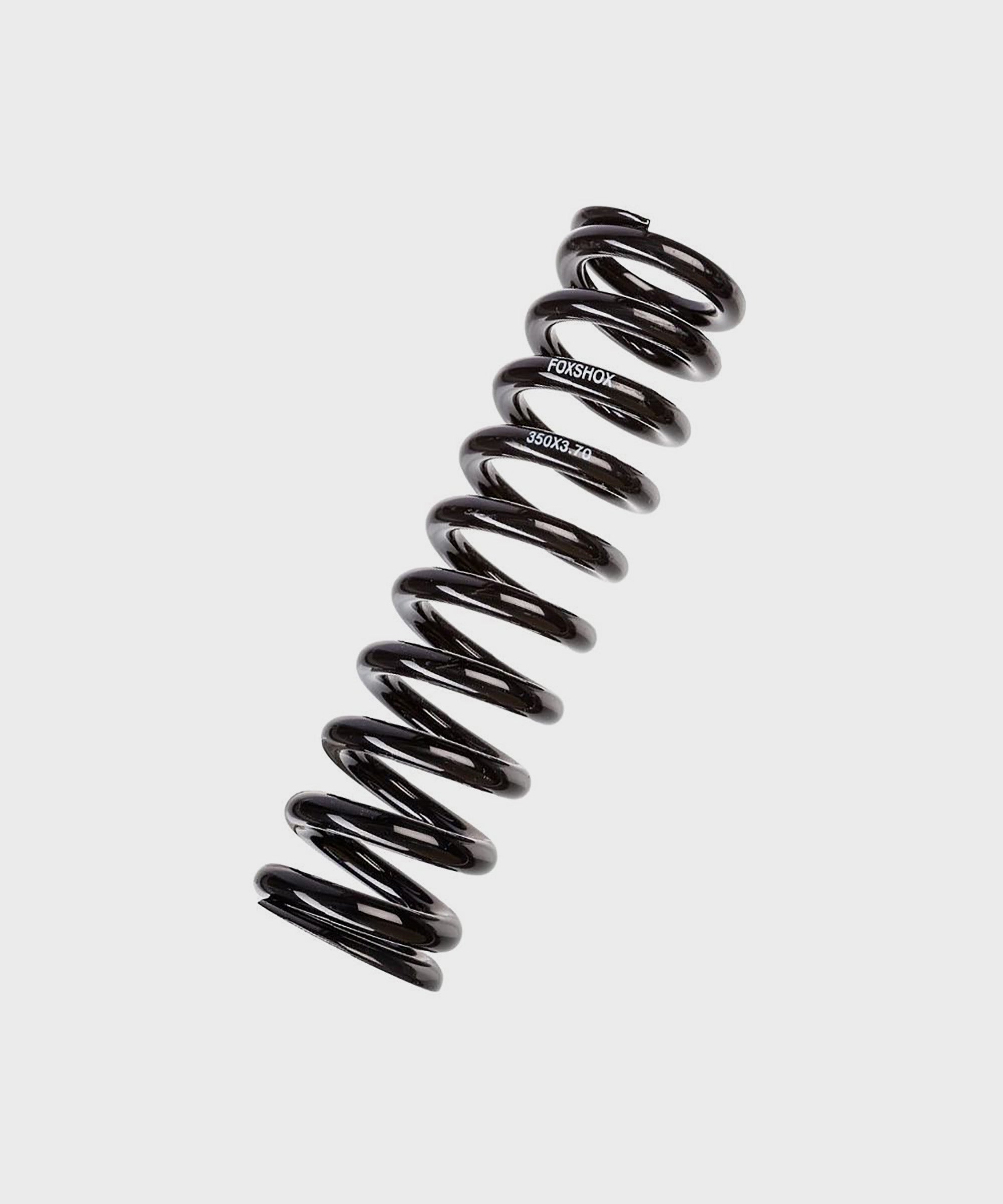 Close-up of Fox Steel Coil Springs for Fox Shock, genuine replacement components with coiled metal design and branding visible.