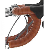 M Part Classic brown bar tape with adhesive and end plugs for road bike handlebars, providing grip and style.