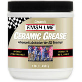 Finish Line ceramic grease tub for bike bearings, lubricant for smooth performance, shown in workshop setting.