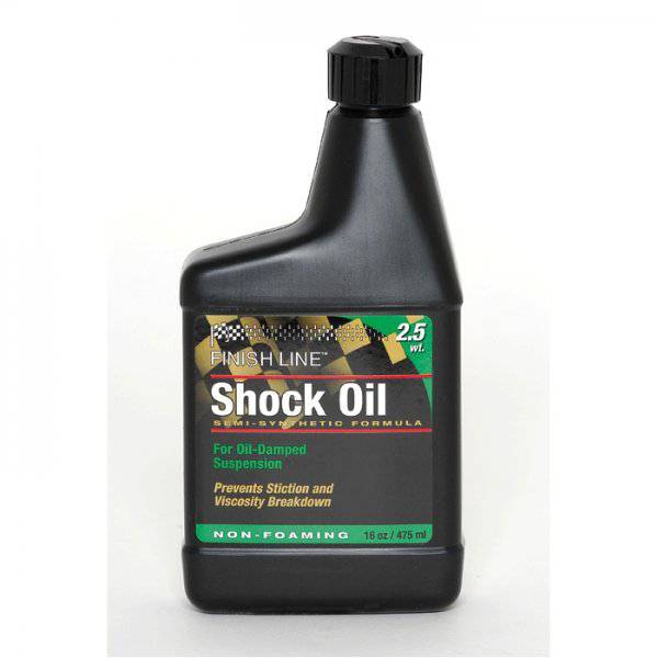 Finish Line Shock Oil 2.5 wt suspension fluid for bicycle forks, shown in 16 oz (475 ml) bottle in a workshop setting.