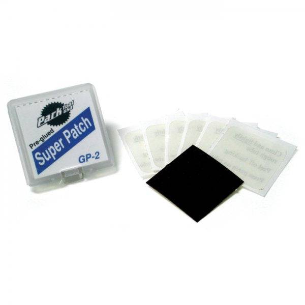 Park Tool GP-2 super patch kit with self-adhesive patches and sandpaper for bike tire repairs in a workshop setting.