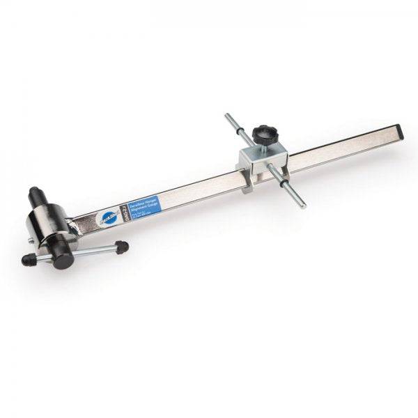 Park Tool DAG-2.2 derailleur hanger alignment gauge for precise bike adjustments, shown in a workshop setting.