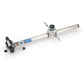 Park Tool DAG-2.2 derailleur hanger alignment gauge for precise bike adjustments, shown in a workshop setting.