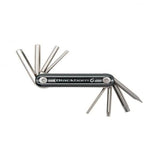 Blackburn Grid 8 Multitool for bikes, compact workshop tool with various repair tools and lifetime guarantee, shown on a workbench.