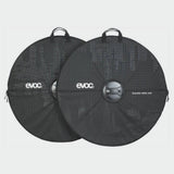 Pair of EVOC black road bike wheel cases with handles and reinforced axle protection for easy transport and storage.