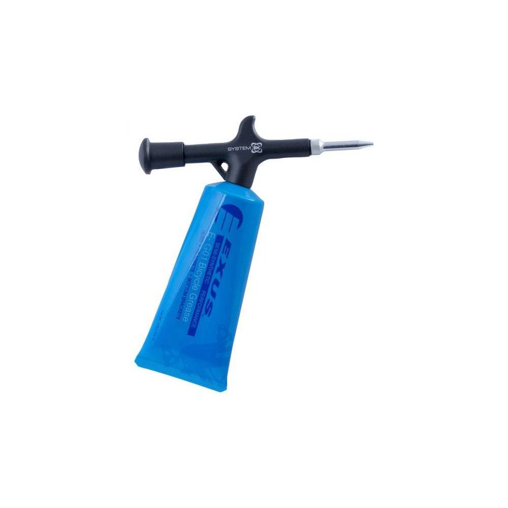 System EX Pro grease gun for bicycle maintenance with long-reach nozzle in black, shown in workshop setting.