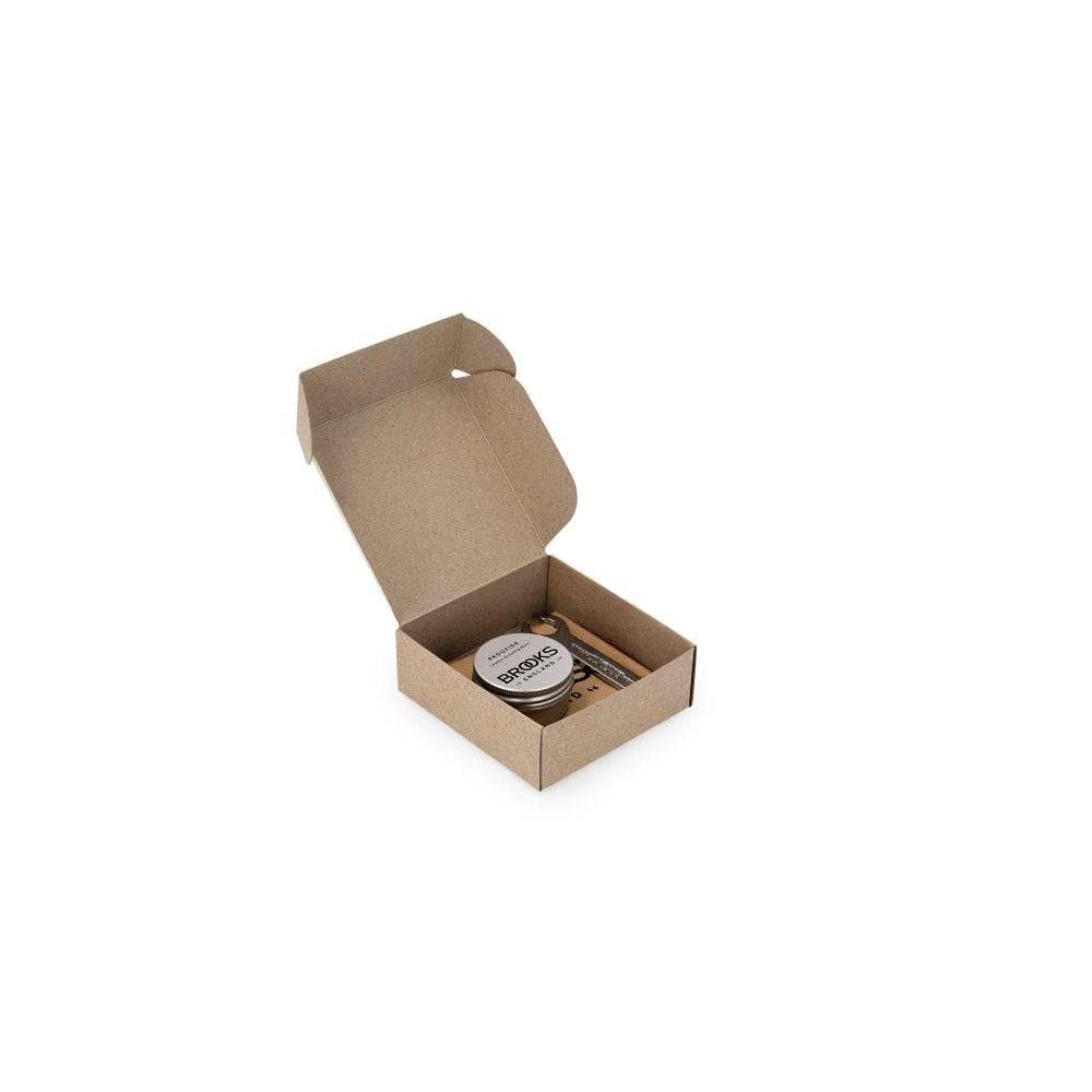 Brooks leather saddle care kit with proofide dressing and spanner for bicycle saddle maintenance, featuring silver components.