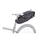Topeak BackLoader bikepacking seat bag with water-resistant fabric and quick-release storage system mounted on a bicycle seat