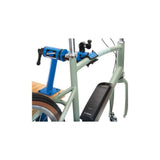 Park Tool PCS-12.2 bike repair stand with micro adjust clamp mounted on a workshop bench for home bike maintenance.