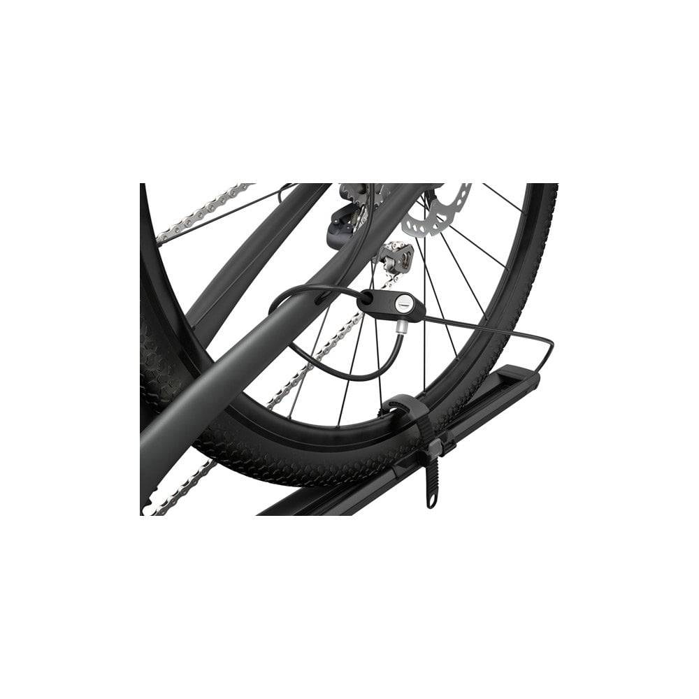 Thule 564 FastRide bike carrier with lock mounted on a vehicle roof rack, holding a quick-release front fork bike.