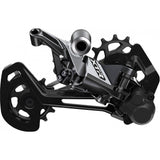 Shimano XTR RD-M9100 12-speed MTB rear derailleur with Shadow Plus design, mounted on a mountain bike drivetrain.