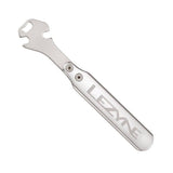 Lezyne CNC pedal rod wrench with integrated 15mm bottle opener for bike repair, shown in a workshop setting.