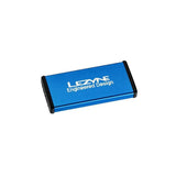 Lezyne Metal Patch Kit with waterproof aluminium case for quick tyre repairs, shown in a workshop setting.