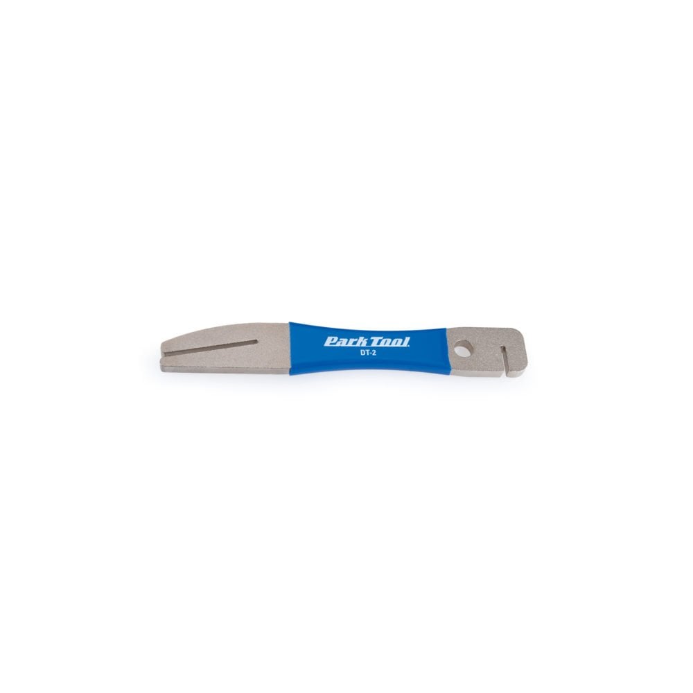 Park Tool DT-2 rotor truing fork for precise disc brake rotor adjustment, shown in a workshop setting with tools and bike components.