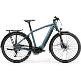 Merida eSpresso 500 EQ urban e-hybrid bike with Shimano STEPS motor and accessories, shown outdoors with a city background.