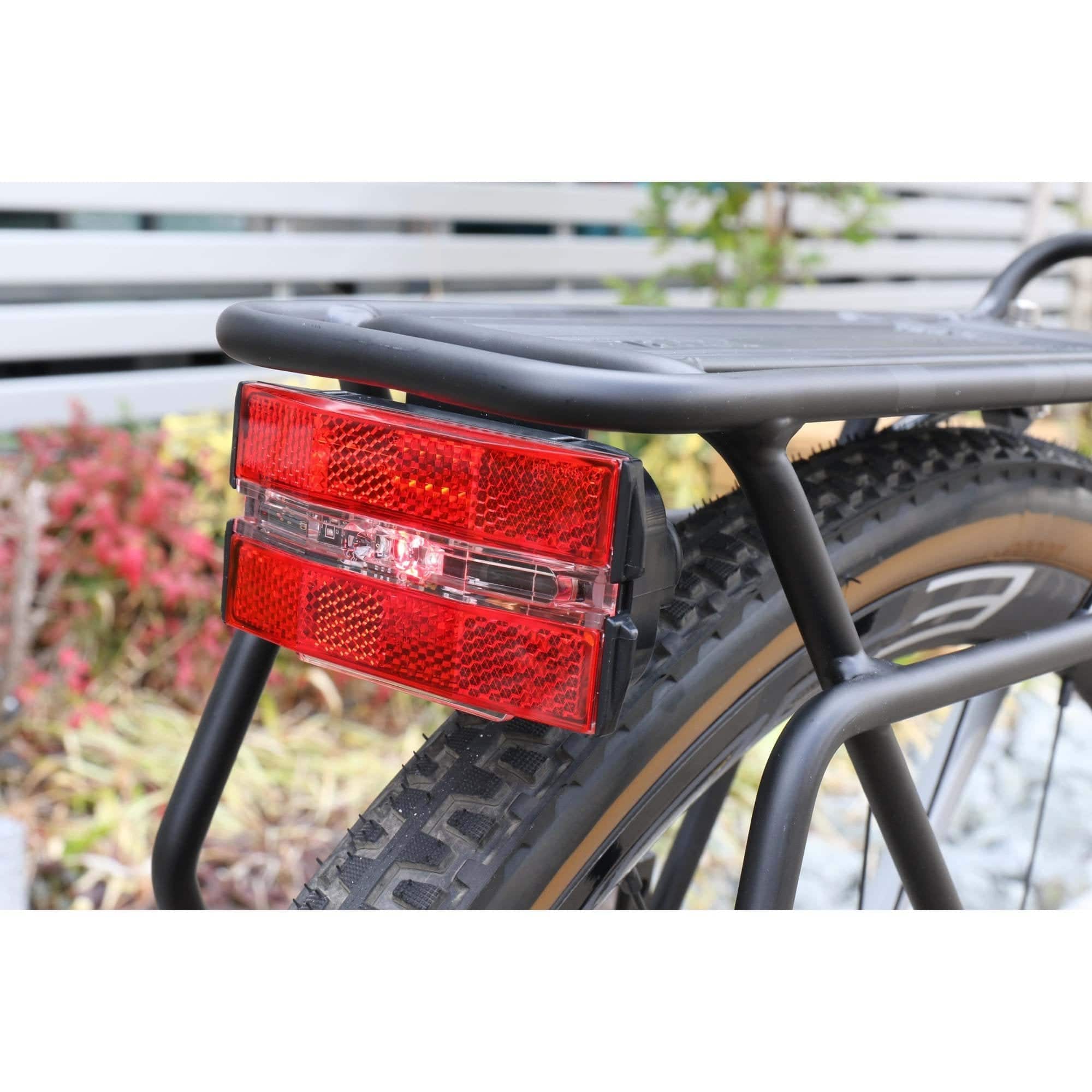 Cateye Reflex rear bike light with reflector, rack mount, battery-powered cycling accessory, visible on a bike for safety.