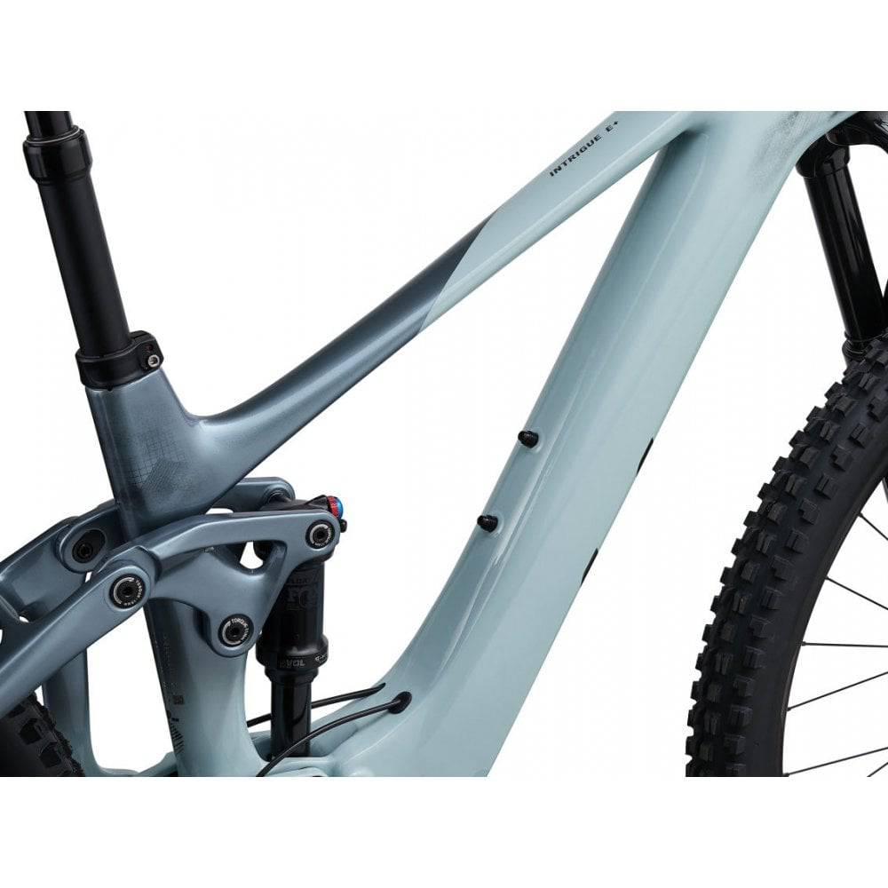 Liv Intrigue X Advanced E+ EL 2 women's electric mountain bike with SyncDrive Pro motor and 25km/h speed in a scenic outdoor setting