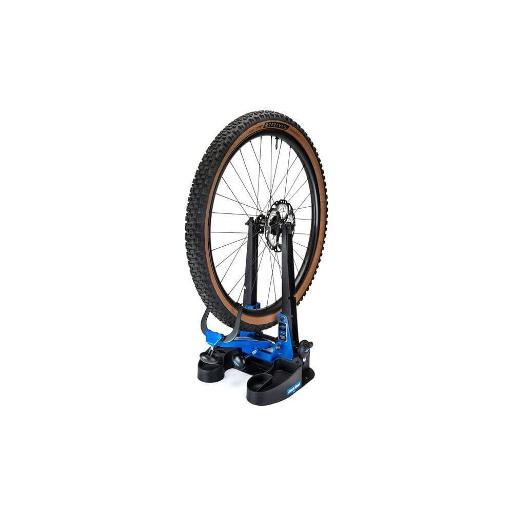 Park Tool TS-2.3 professional wheel truing stand for road, MTB, and BMX wheels in a workshop setting.