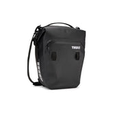 Pair of Thule Shield waterproof panniers with reflective panels, designed for touring and commuter bikes, mounted on bike racks.