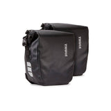 Pair of Thule Shield waterproof bike panniers with reflective panels, designed for touring and commuting cycling accessories.