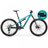 Merida One-Forty 700 mountain bike with Shimano SLX 12-speed drivetrain and premium suspension, shown outdoors with rugged trail background.