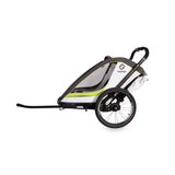 Hamax Breeze child bike trailer with stroller wheel and safety features, showing the bright red trailer attached to a bike.