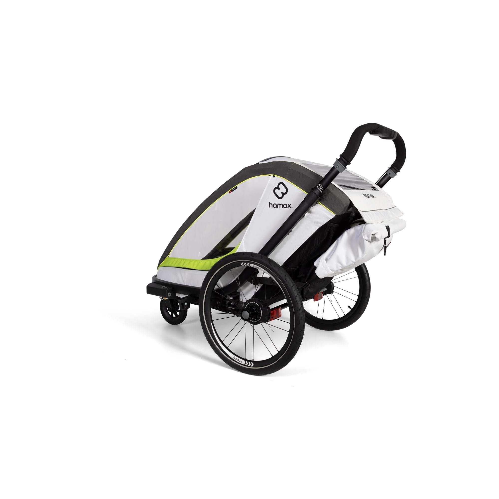 Hamax Breeze child bike trailer with stroller wheel attachment, safety harness, and reflective accents for secure outdoor rides.