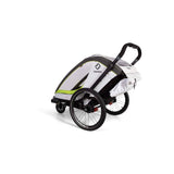 Hamax Breeze child bike trailer with stroller wheel attachment, safety harness, and reflective accents for secure outdoor rides.