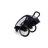 Hamax Breeze child bike trailer with stroller wheel and safety features, showing the compact, secure design for kids' outdoor rides.