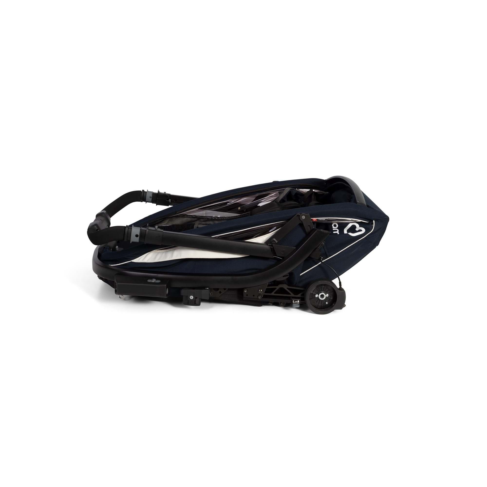 Hamax Breeze child bike trailer with stroller wheel and safety features, showing the trailer's compact, secure design and safety harness.