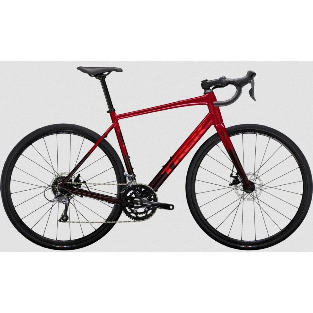 Trek Domane AL 2 Gen 4 road bike with Shimano Claris 8-speed drivetrain and disc brakes, black and red frame, on a road.