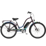 Electra Townie Go! 5i EQ step-through electric hybrid bike with Bosch Active Line Plus motor, shown outdoors with rider.