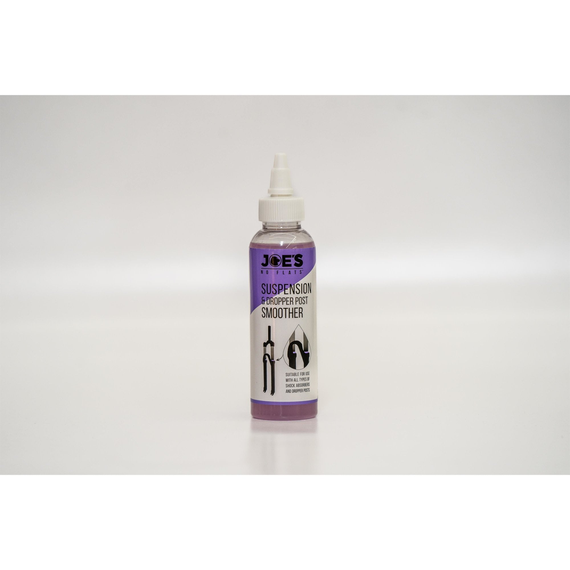 Joe's No Flats Suspension & Dropper Post Smoother Lube for bike shocks, 125ml, in a workshop setting, with lubricant bottle visible.