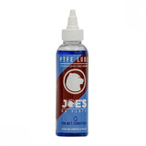 Joe's No Flats PTFE Wet Lube bicycle chain lubricant for wet and muddy conditions, shown in a workshop setting.