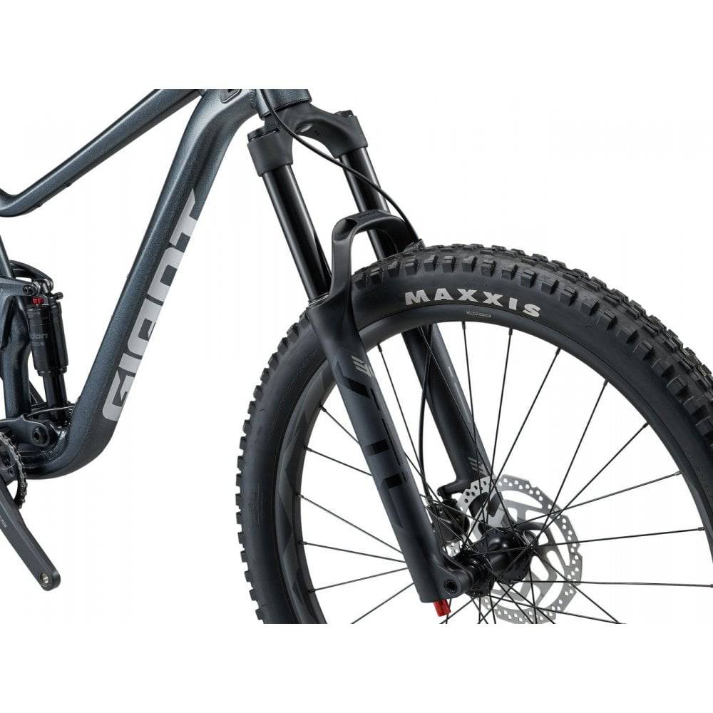 Giant Stance mountain bike with 125mm rear suspension, 140mm fork, black frame, and knobby tires for trail riding.