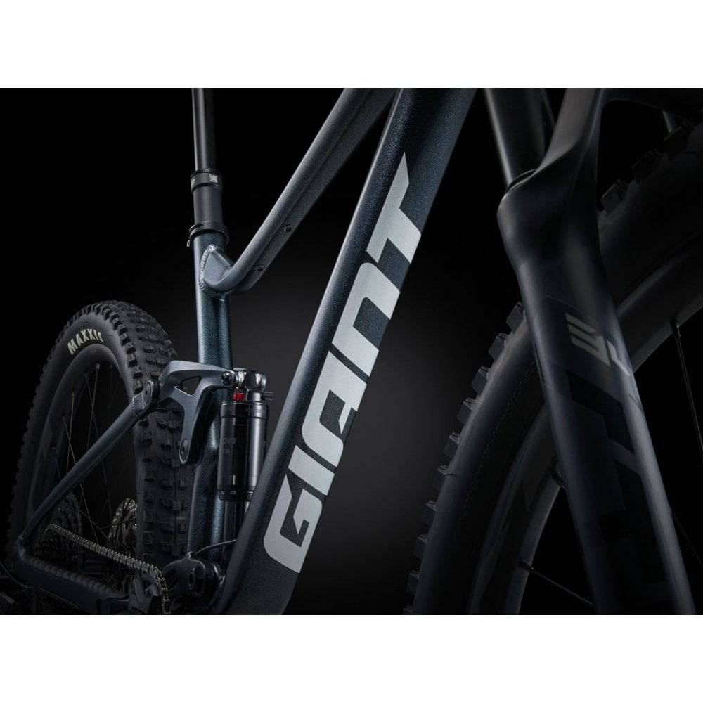 Giant Stance mountain bike with 125mm rear FlexPoint suspension and 140mm front fork, black and red frame, ready for trail riding.