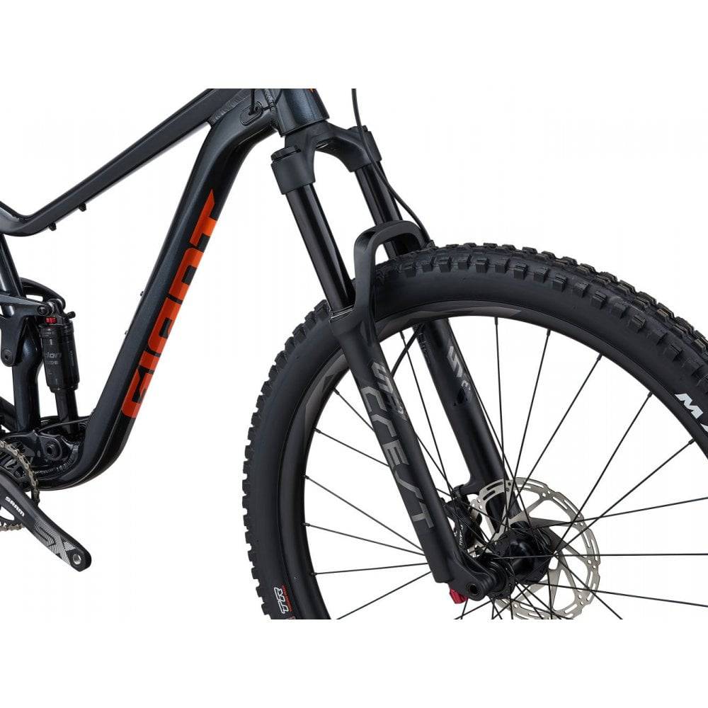 Giant Stance 29 1 full suspension mountain bike with FlexPoint suspension system, black and green frame, off-road trail scene
