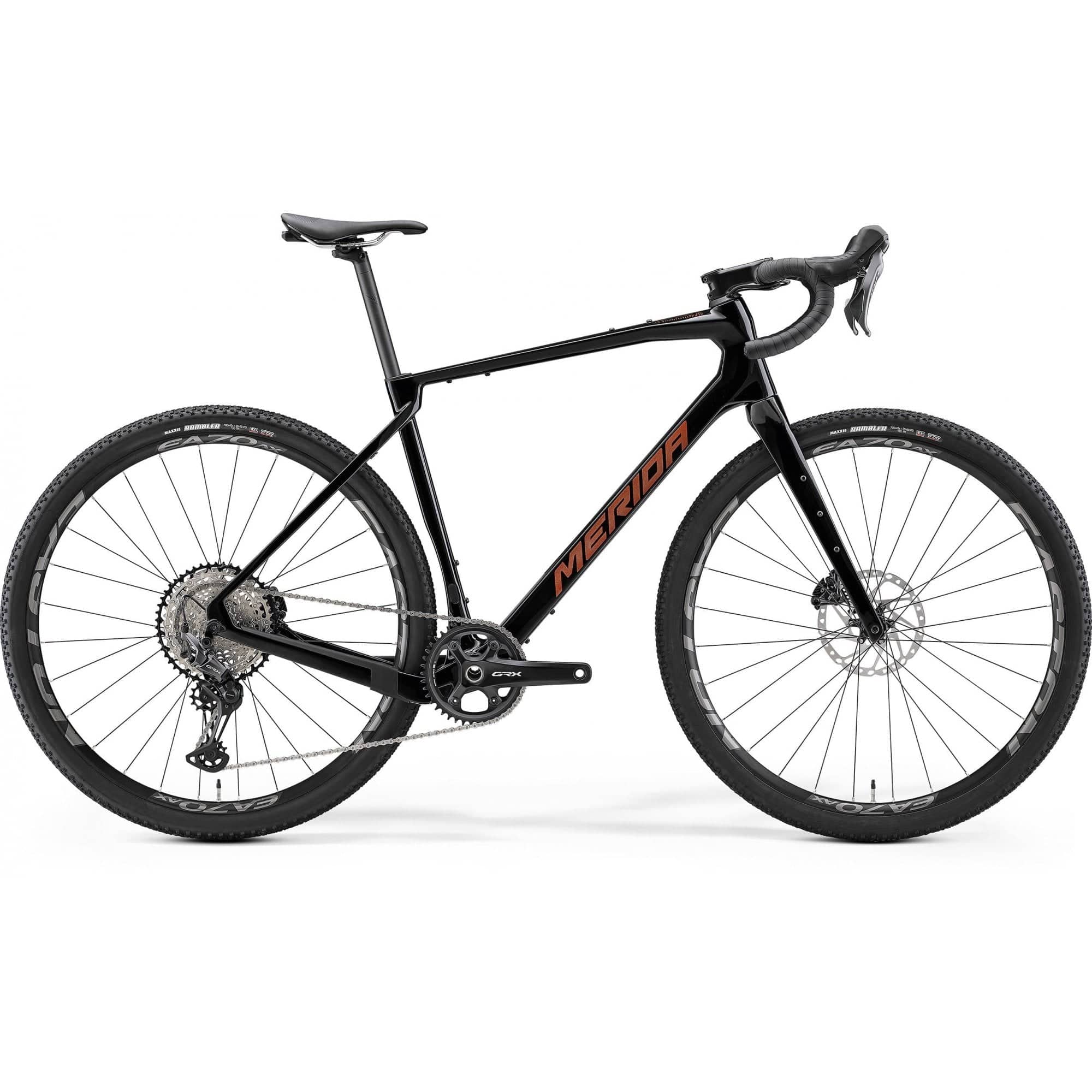 Merida Silex 7000 MY24 gravel bike in black, bronze, and gold with off-road tires and sleek frame for adventure riding.