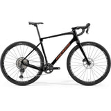 Merida Silex 7000 MY24 gravel bike in black, bronze, and gold with off-road tires and sleek frame for adventure riding.