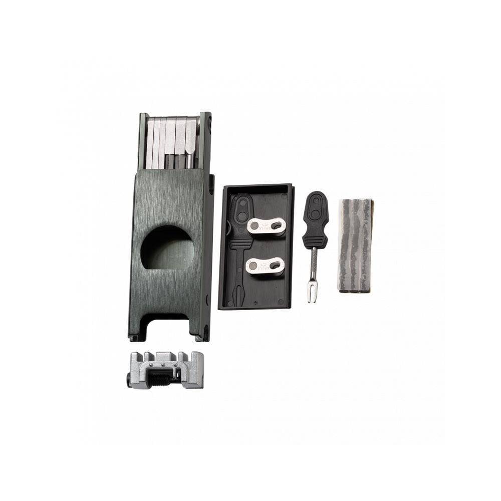 Crankbrothers F16 black multi-tool for tubeless bike repair with 16 functions, displayed on a workshop workbench.