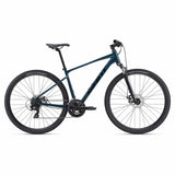 Giant Roam Disc 4 hybrid bike 2024 with XL frame, Shimano Tourney gears, and disc brakes, shown outdoors with a city background.