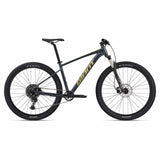 Giant Talon 1 2024 unisex mountain bike with Shimano CUES U6000 disc brakes, shown on rugged outdoor trail