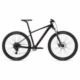 Giant Talon 2 2024 mountain bike with Shimano CUES U4000 drivetrain and disc brakes, shown on rugged trail.