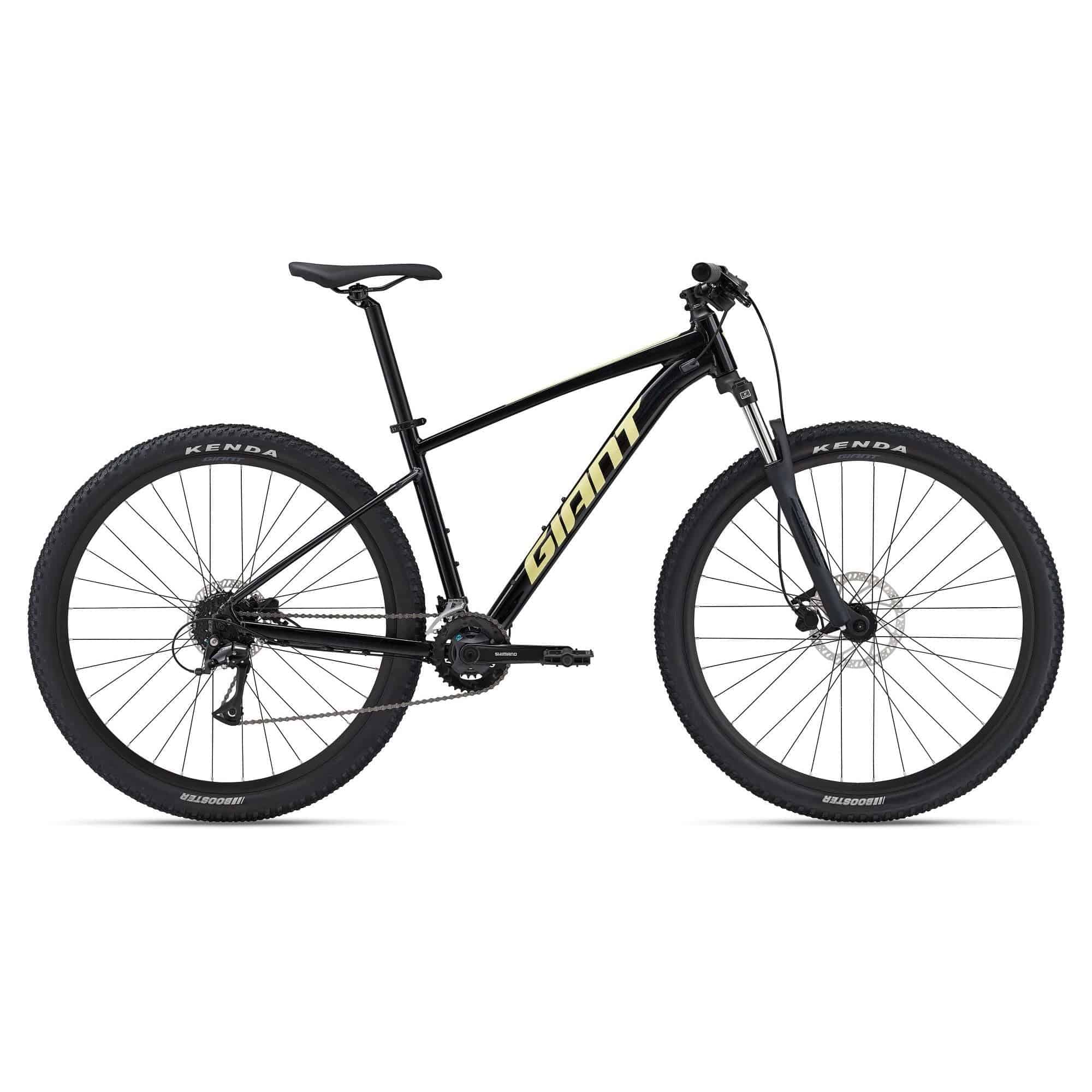 Giant Talon 3 2024 mountain bike with medium frame, Shimano Acera gears, disc brakes, and rugged tires on trail.