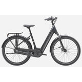 Trek District+ 3 lowstep e-hybrid bike for urban commuting and light trails with sleek frame and electric assist in a city setting.