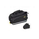 Topeak MTX TrunkBag DX 2.0 in black attached to bike rack, showing multiple compartments and reflective safety features.
