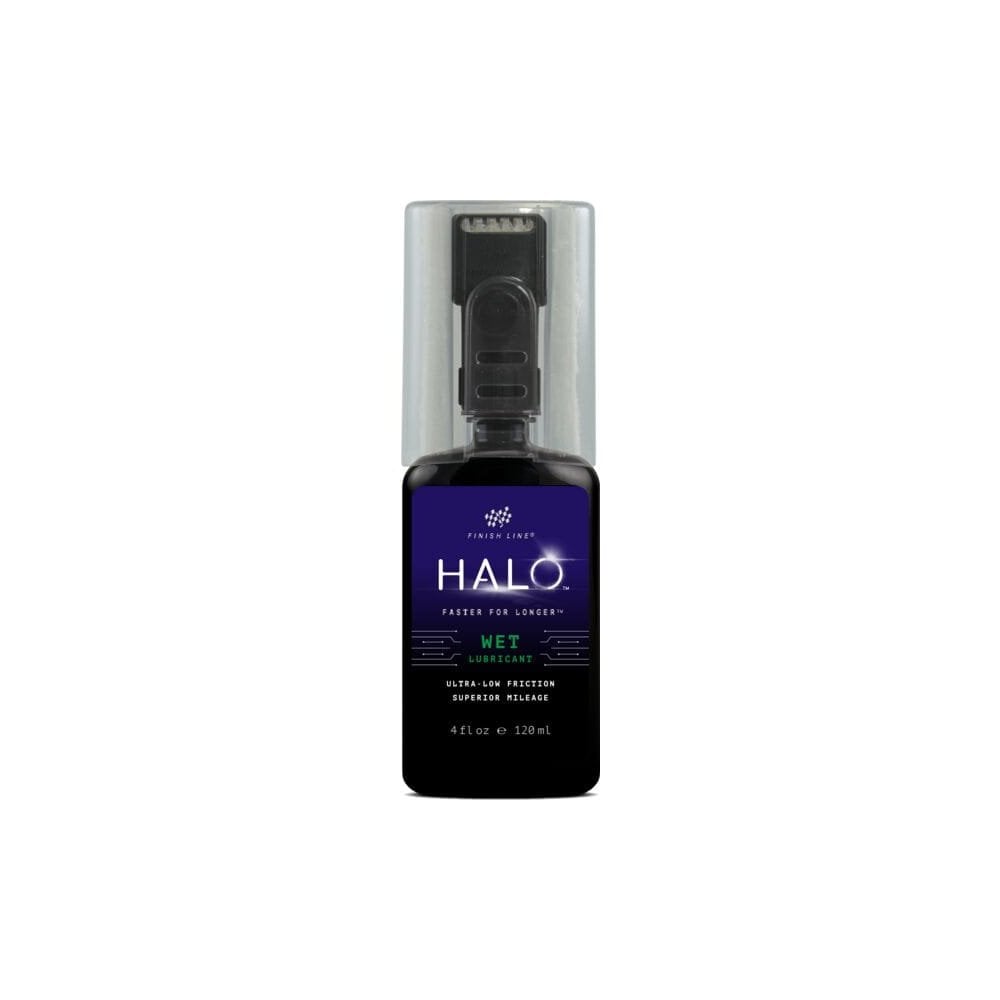 Finish Line Halo Wet Lubricant bottle for bicycle chains, featuring Smart Luber™ technology in a workshop setting.