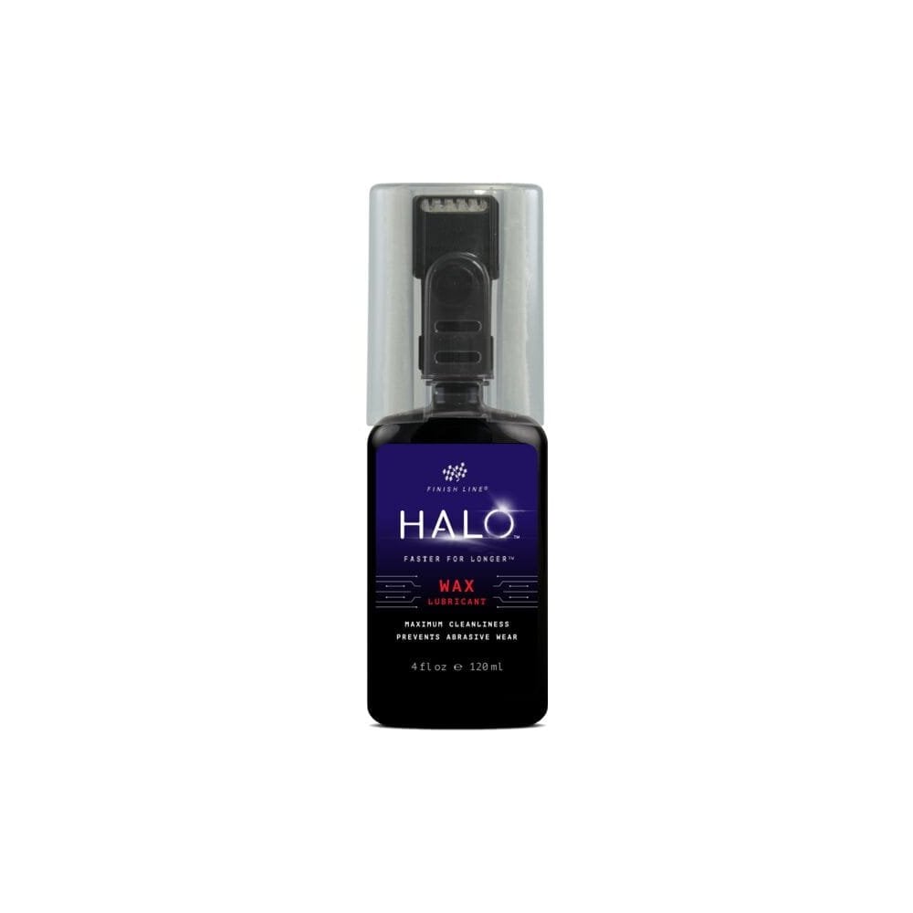 Finish Line Halo Wax bicycle chain lubricant with Smart Luber for drivetrain maintenance, shown in workshop setting.