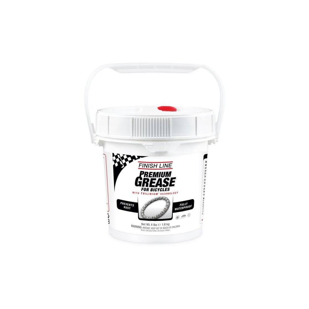 Finish Line Premium Ceramic Tech Grease tube for high-performance bike lubrication, shown in a workshop setting.