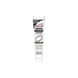 Finish Line Premium Ceramic Tech Grease tube for high-performance bike lubrication, shown in a workshop setting.